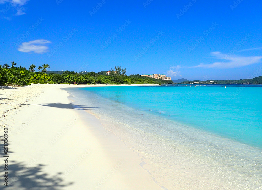 Beautiful Lindquist beach day on St. Thomas US Virgin Islands with clear blue skies, palm trees and turquoise water.