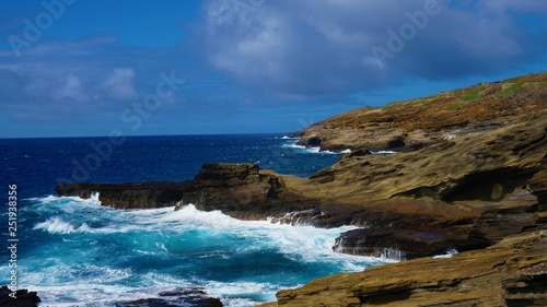 Blue ocean waves hit Hawaii rock coast 