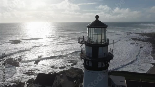Close up  of the lighthouse on the coast in the pacific ocean, very cinematic, aerial shot