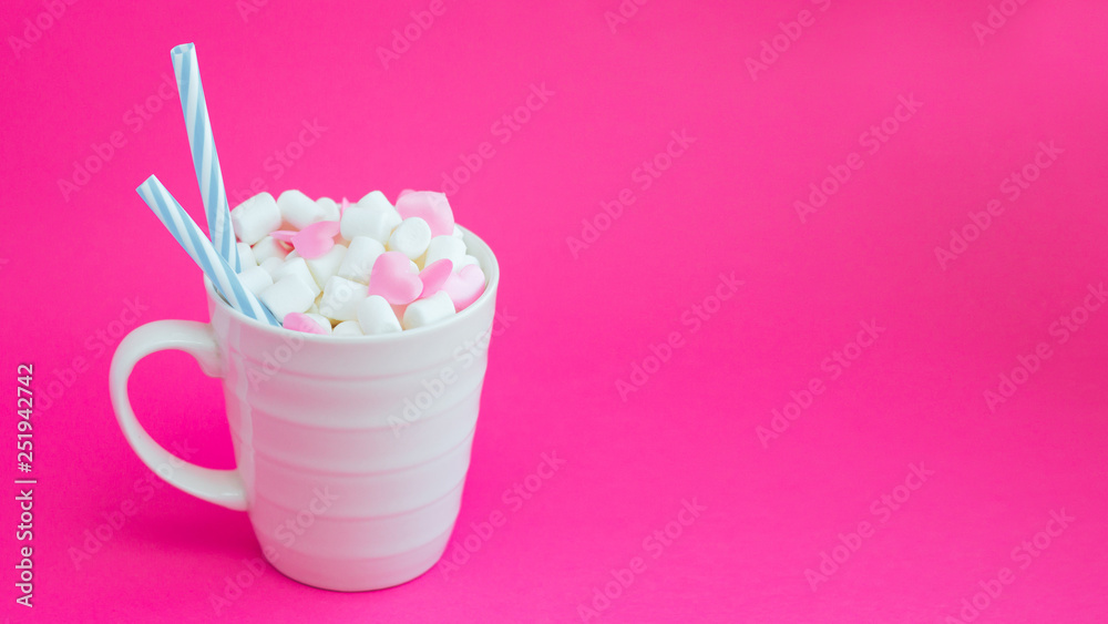 Mug with marshmallows in the shape of heart on pink background Mug with marshmallows in the shape of heart on pink background