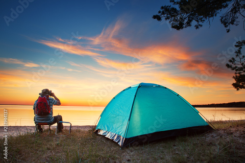 Family resting with tent in nature at sunset