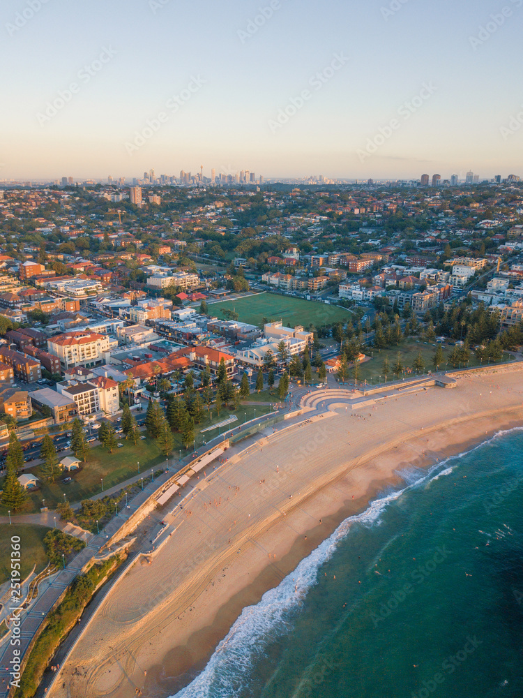 Aerial view of Coogee Beach with Sydney skyline at the distance.
