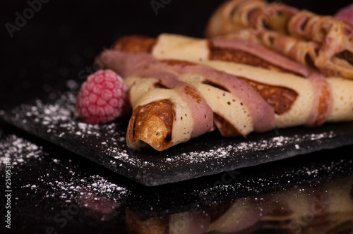 crepes on a plate with raspberries