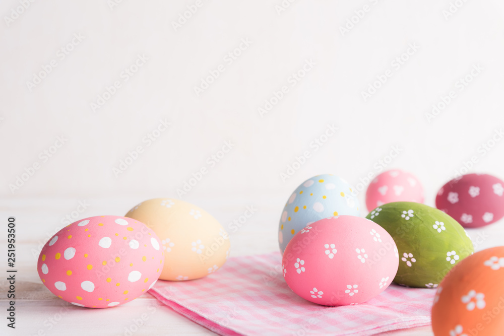 Happy easter! Colorful of Easter eggs with pink and white cheesecloth on wooden background.