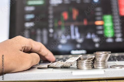 hand touching keyboard and coin with monitor shows trading traffic, Bitcoin minning photo