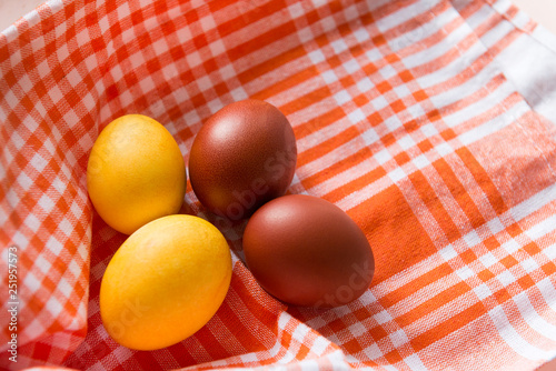 4 Easter eggs, yellow and brown boiled eggs on an orange towel photo