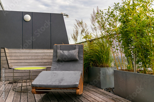 Rocking lounger on a roof terrace with bamboo and grasses