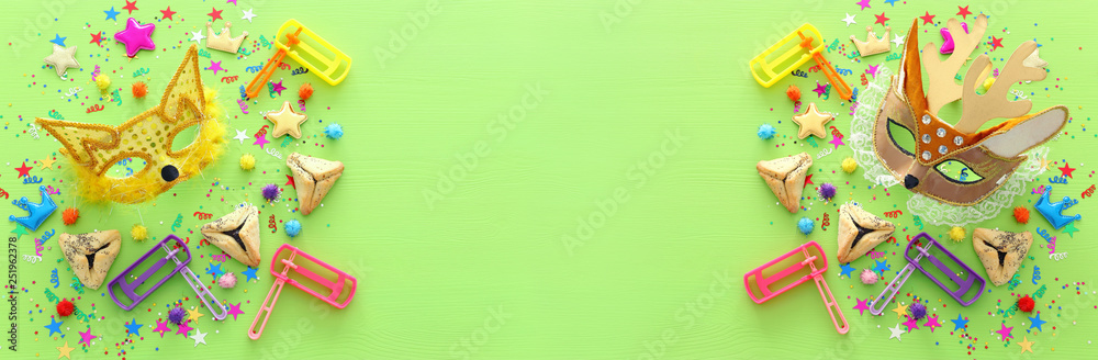 Obraz premium Purim celebration concept (jewish carnival holiday) over wooden green background. banner