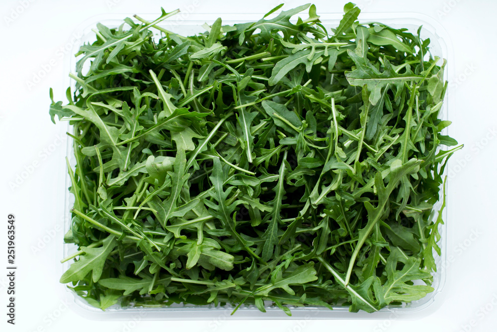Green arugula on white background. The concept of food. Green arugula on white background. The concept of food.