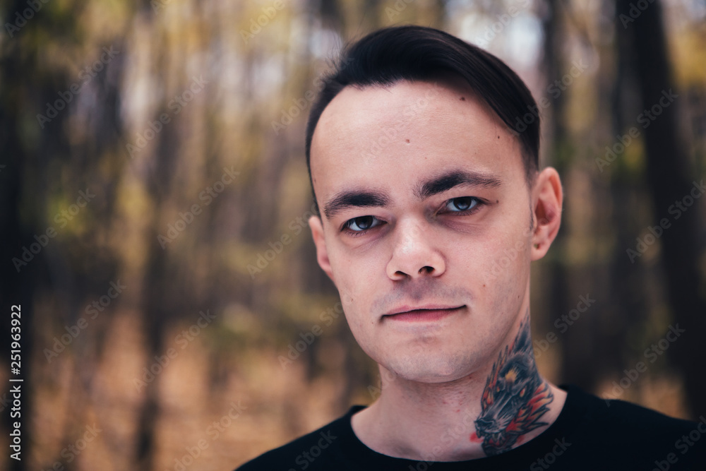 portrait of a man with tattoo in the autumn forest portrait of a man with tattoo in the autumn forest
