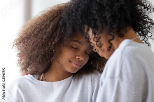 African mother and daughter touching foreheads having close strong connection