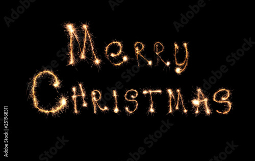 Sparklers forming text MERRY CHRISTMAS on black background