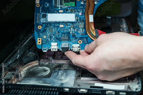 man holding laptop motherboard. dusty laptop photo