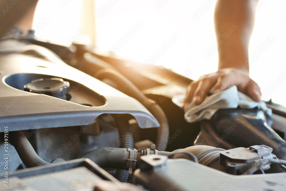 Auto mechanic repairing car in service center, closeup