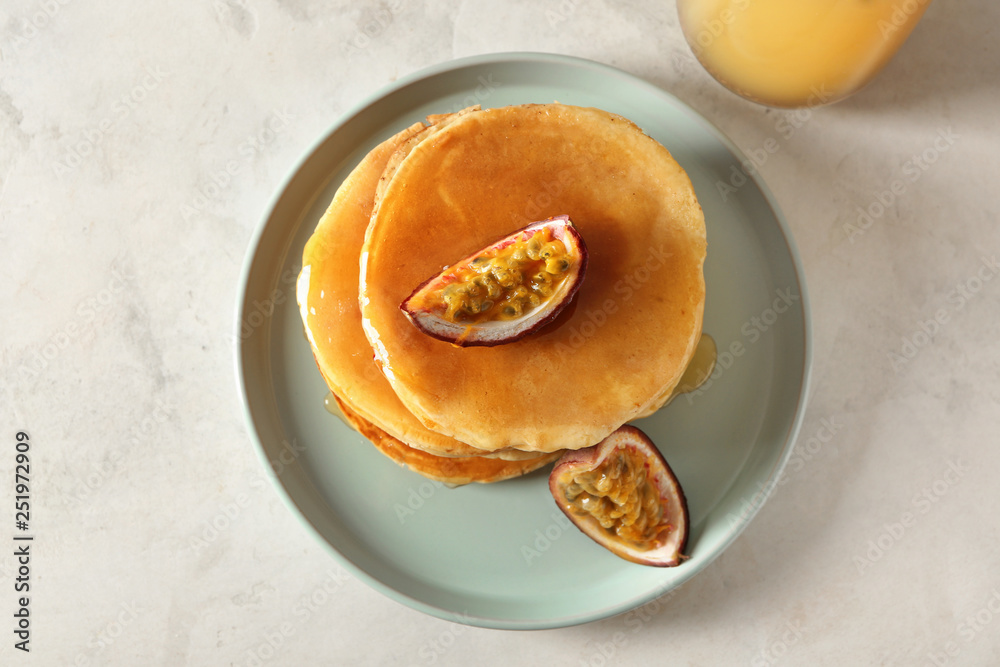 Tasty pancakes with passion fruit on light table