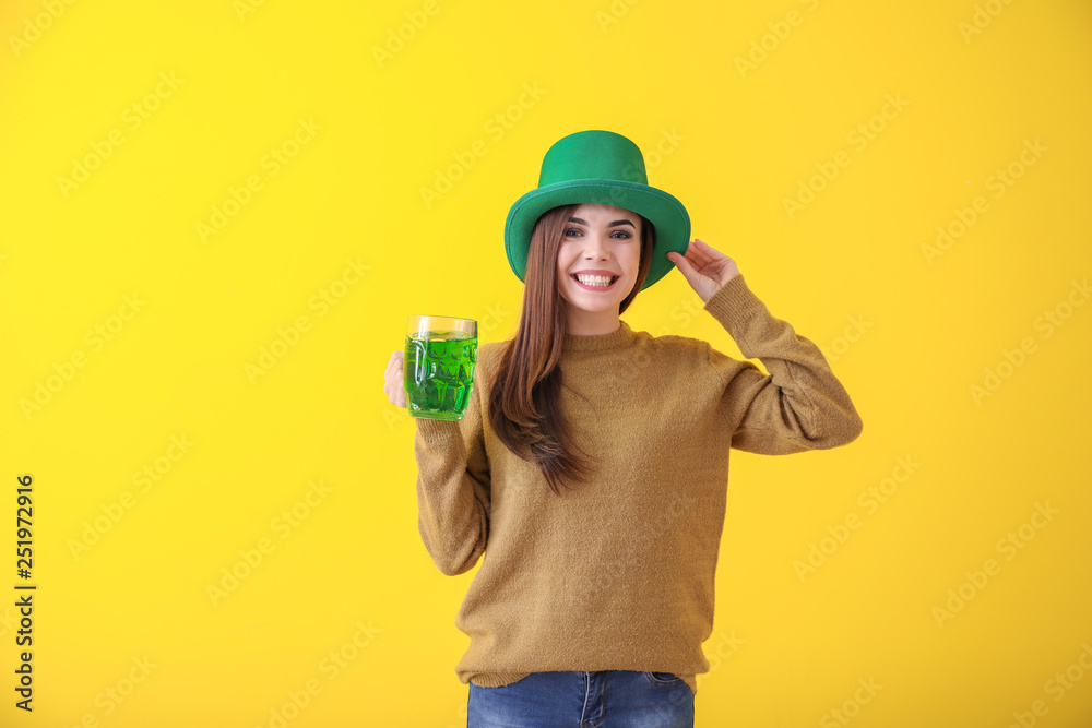 Beautiful young woman in green hat and with mug of beer on color background. St. Patrick's Day celebration Beautiful young woman in green hat and with mug of beer on color background. St. Patrick's Day celebration