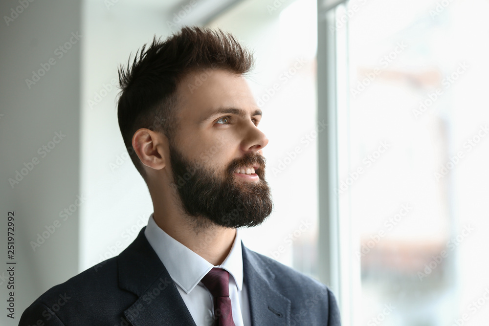 Portrait of handsome businessman near window in office Portrait of handsome businessman near window in office