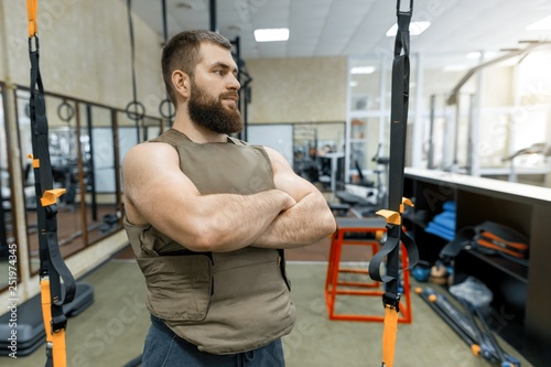 Portrait muscular caucasian bearded adult man in gym, dressed in bulletproof armored vest, military sport © Valerii Honcharuk