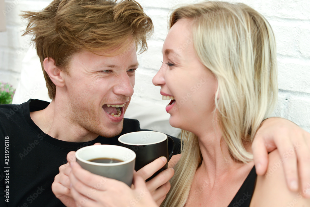 Beautiful young smiling woman sitting on bed with a cup of coffee in the morning at bedroom. Beautiful young smiling woman sitting on bed with a cup of coffee in the morning at bedroom.