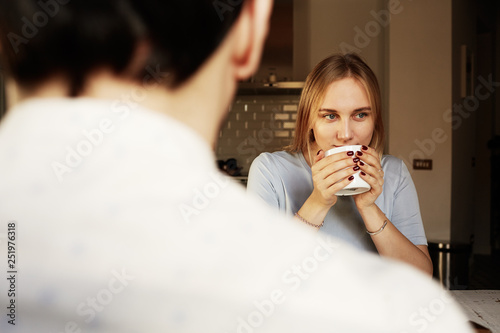 Conversation of confident man and young blond woman at home.