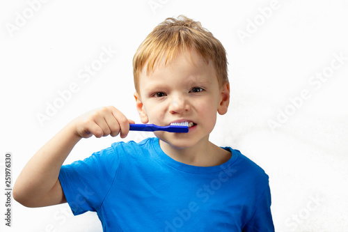 Kid brushing teeth with toothbrush and smiling happily