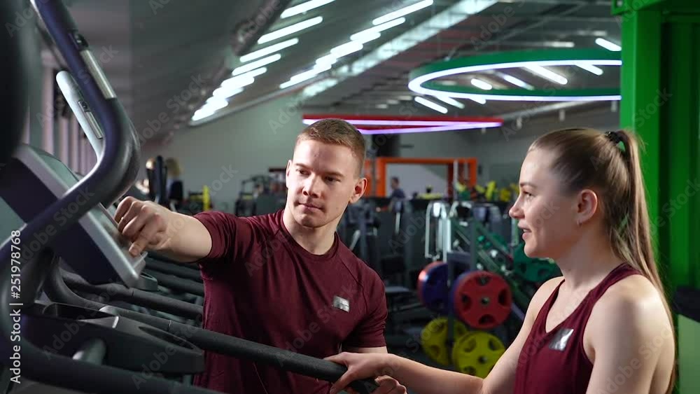 Fitness, sports and active lifestyle - trainer and young woman in the gym. Fitness, sports and active lifestyle - trainer and young woman in the gym.
