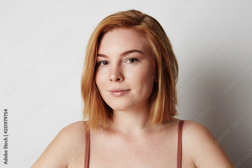 Profile portrait of beauty female redhead model with happy smiling and light nude make-up. Background Profile portrait of beauty female redhead model with happy smiling and light nude make-up. Background