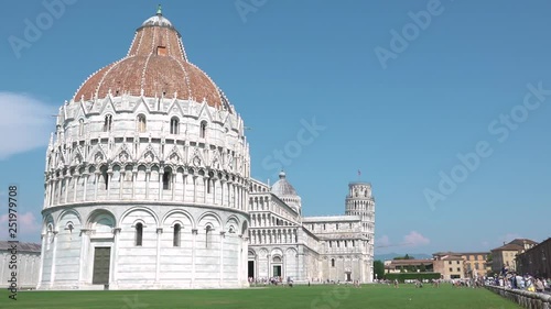 View of Piazza dei Miracoli of Pisa, Tuscany, Italy, with leaning tower, cathedral and baptistery. Tourist walking along main square with famous monuments, Italian attraction, tourism destination