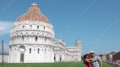Smiling couple taking selfie with Pisa tower, Italian tourism destination. Happy people travel to Tuscany, cheerful tourists with leaning tower, cathedral and baptistery, photo of holidays in Italy