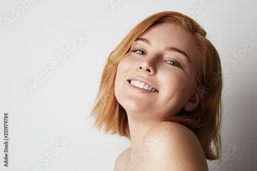 Profile portrait of beauty female redhead model with happy smiling and light nude make-up. Background