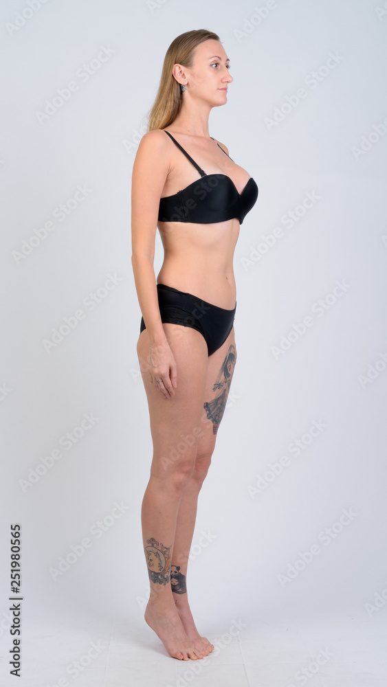 Full body shot of blonde woman wearing bikini thinking