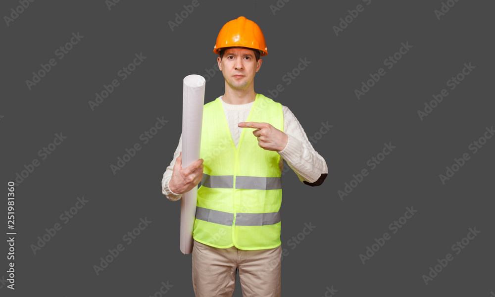 the civil engineer in a helmet points a finger at documents
