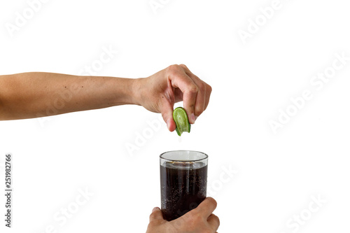 Squeezing the lime into the drink