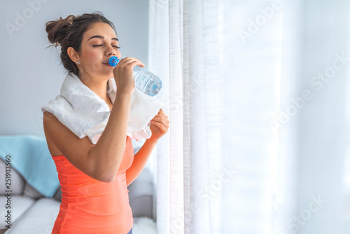 Young athletic woman drinking water