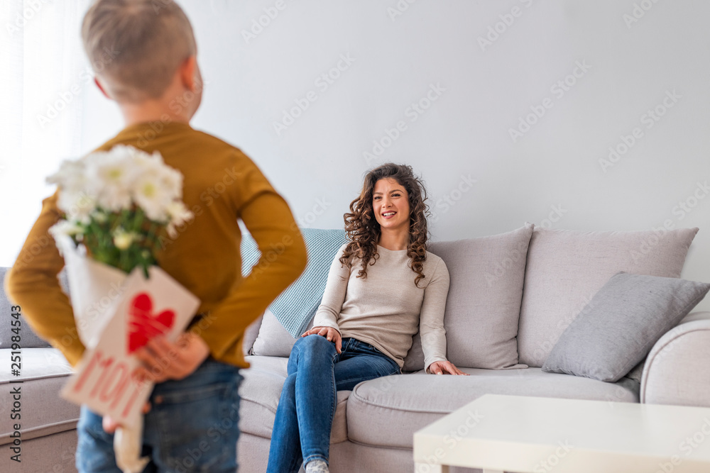 Happy mother hugging her adorable little boy and holding greeting card for Mothers Day Happy mother hugging her adorable little boy and holding greeting card for Mothers Day