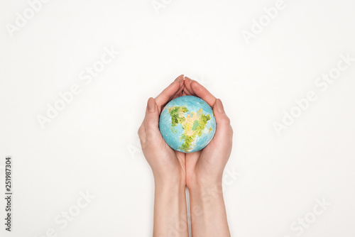 cropped view of female hands with globe model on white background, global warming concept