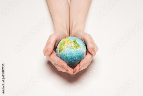 cropped view of woman holding globe model on white background, global warming concept