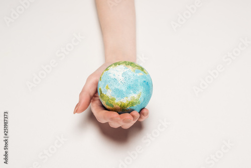 partial view of female hand with earth model on white background, global warming concept