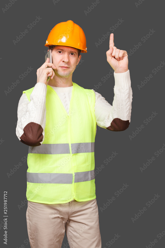 the man in a helmet speaks by phone, points a finger up the man in a helmet speaks by phone, points a finger up