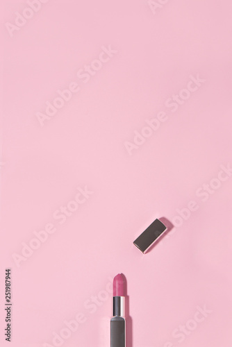 Opened lipstick on pink background. Beauty and fashion conception.
