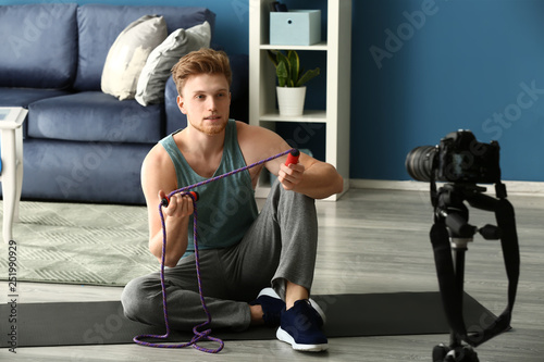 Fototapeta Naklejka Na Ścianę i Meble -  Young male sport blogger recording video at home