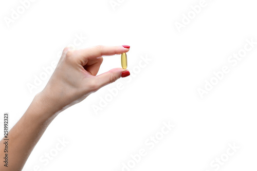 Hand holding capsule of Omega 3 on white background. Close up. High resolution product. Health care concept