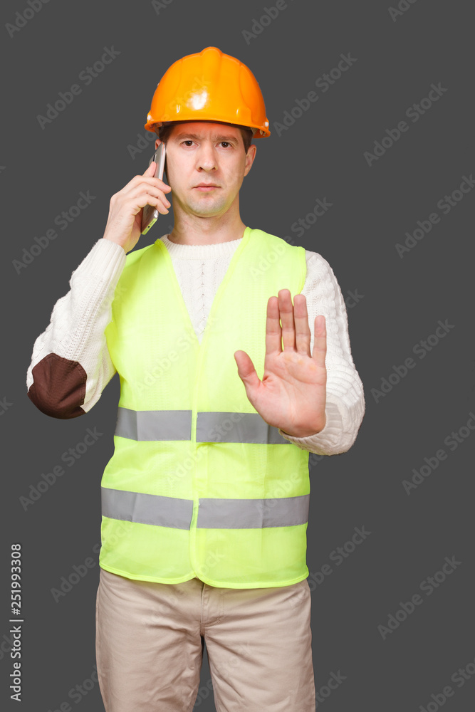 the man in a helmet with phone, urges to stop gesture the man in a helmet with phone, urges to stop gesture