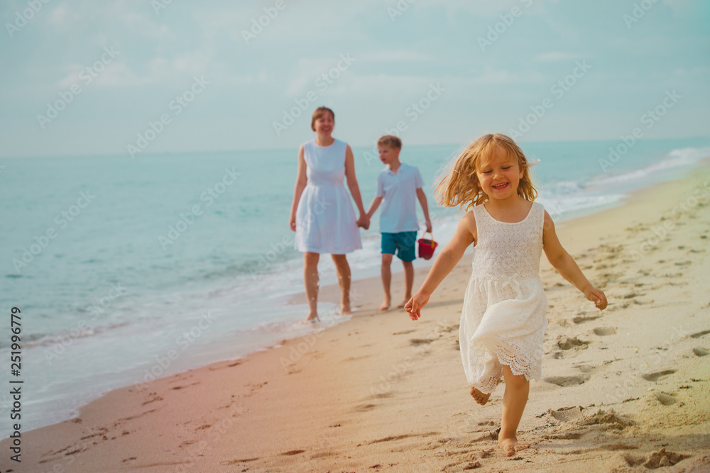 happy family on beach, cute little girl with mom and brother at sea