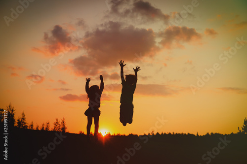 silhouette of happy boy and girl enjoy sunset nature