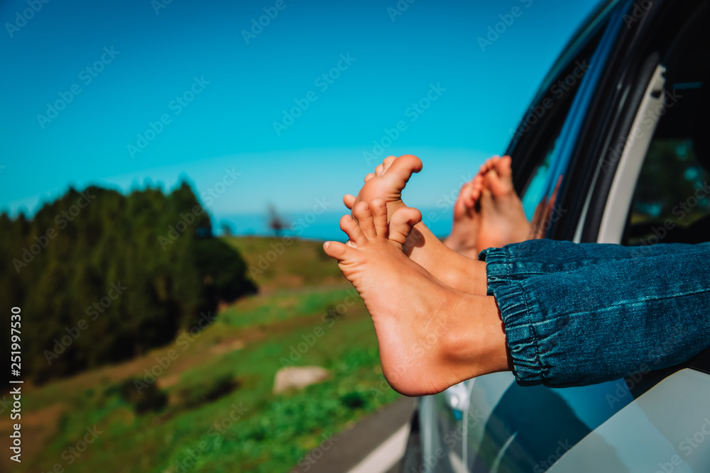 feet of happy kids travel by car in nature