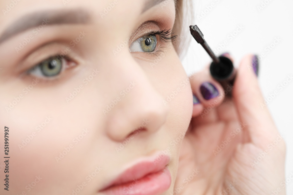 Make-up artist paints a girl with black mascara eyelashes closeup. Make-up artist paints a girl with black mascara eyelashes closeup.