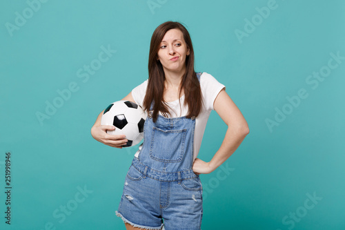 Confused displeased young woman football fan support favorite team with soccer ball isolated on blue turquoise background. People emotions sport family leisure lifestyle concept. Mock up copy space. © ViDi Studio