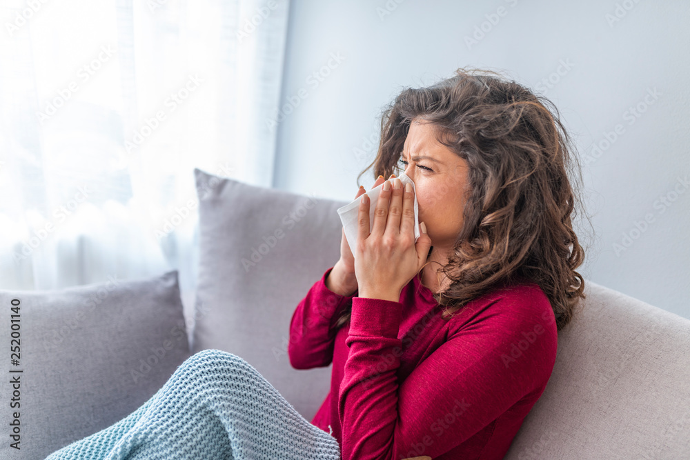 Sick Woman.Flu.Woman Caught Cold. Sneezing into Tissue. Headache. Virus .Medicines. Young Woman Infected With Cold Blowing Her Nose In Handkerchief. Sick woman with a headache sitting on a sofa Sick Woman.Flu.Woman Caught Cold. Sneezing into Tissue. Headache. Virus .Medicines. Young Woman Infected With Cold Blowing Her Nose In Handkerchief. Sick woman with a headache sitting on a sofa