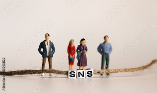 Miniature people. A SNS alphabetical cube that is connected by a string.